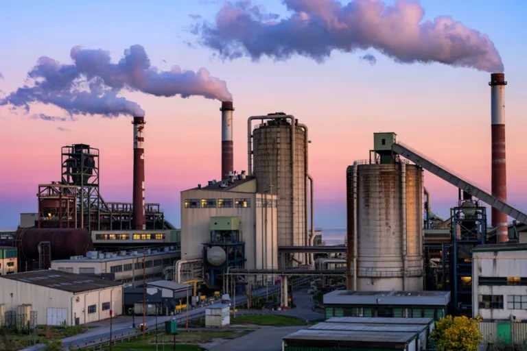 Factory smokestacks against a sunset sky